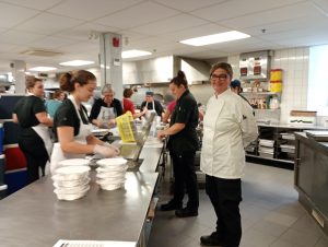 Bénévoles qui travaillent dans les cuisines d'une popote roulante dans l'article Pourquoi les popotes roulantes sont vitales au Québec #popotesroulantes #RPRQ